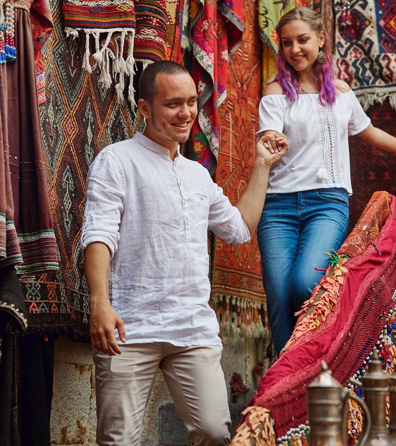 Couple in love chooses a Turkish carpet at the market. Cheerful joyful emotions on the face of a man and a woman. Valentines Day in Turkey